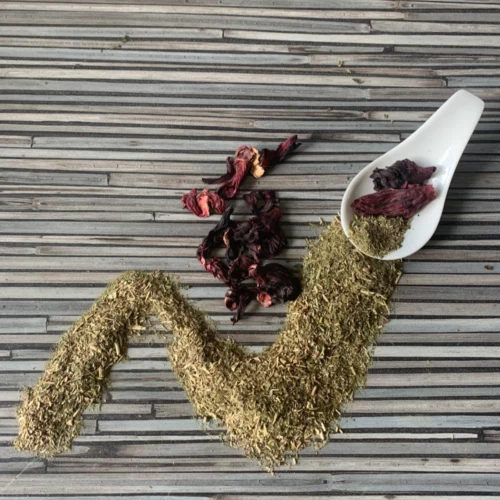 Apoyar mit Hibiskus mit weißem Porzellanlöffel auf gestreifter Arbeitsplatte.