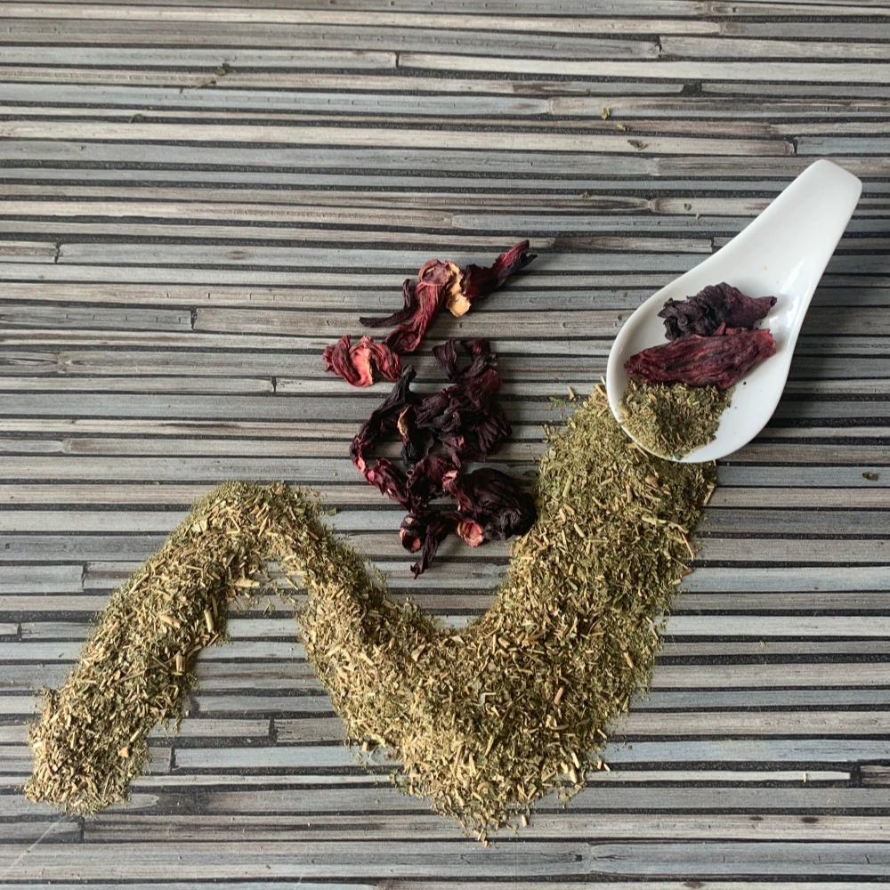 Apoyar mit Hibiskus mit weißem Porzellanlöffel auf gestreifter Arbeitsplatte.