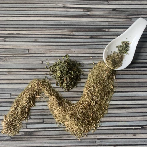 Apoyar mit Nana Minze mit weißem Porzellanlöffel auf gestreifter Arbeitsplatte.