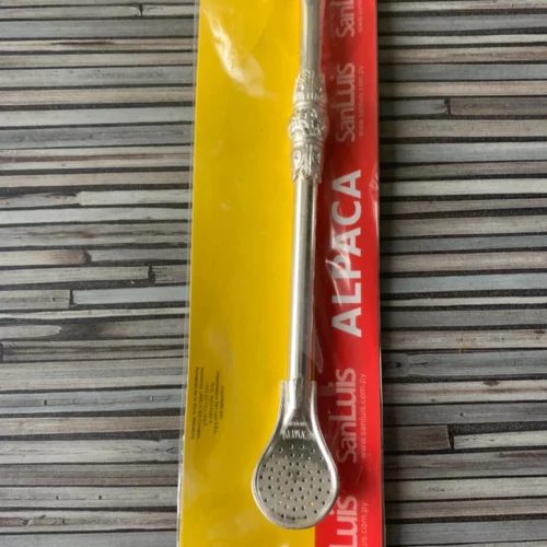 Bombilla Trinkhalm Ornament für Mate in Verpackung silberner Loeffel auf gestreiftem Hintergrund.