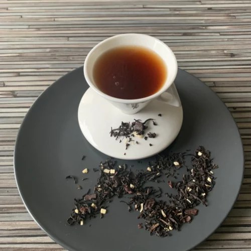 Schwarztee Bon Tea Schokolade Kokos Schwarztee mit Schokoladenstücken und Kokosraspeln in weißer Tasse