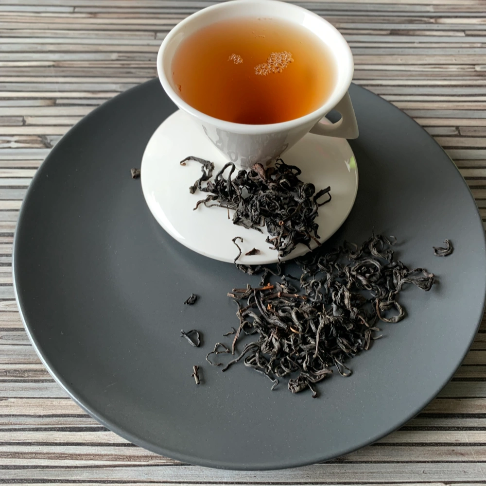 Georgien Wild Grusinien OP auf grauem Teller mit weißer Tasse vor gestreiftem Holzhintergrund