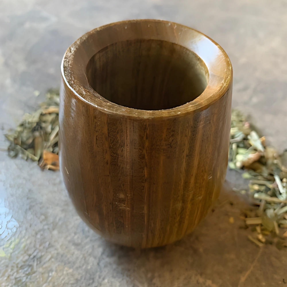 Kalebasse aus Holz Guampa Mate steht auf Marmorhintergrund mit Tee angerichtet