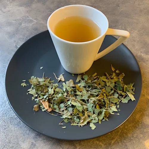 Ein Teller mit Pata de Vaca Tee auf marmorierter Fläche mit Teetasse.