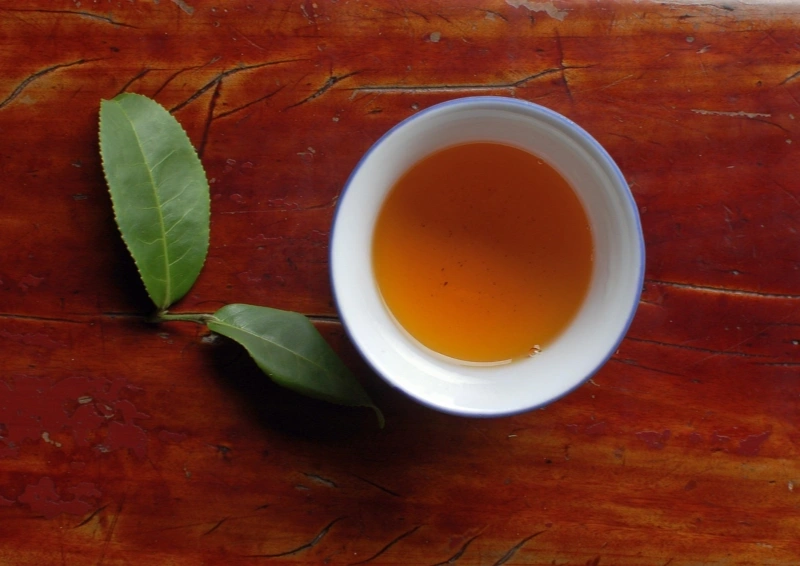 China Huang Ya Yellow Tips in der Teeschale mit Teeblatt.