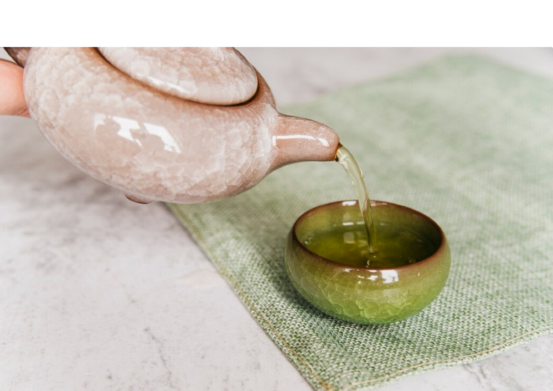 China Oolong Tien Kuan Yin wird eingeschenkt aus rosa Kanne.