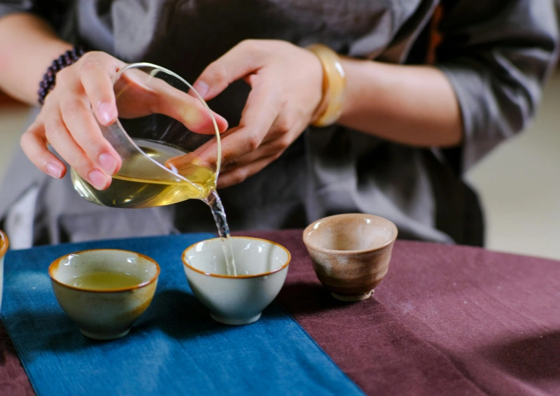 Gelber Tee Gelbe Jade Ringe wird mit einer Glaskanne eingeschenkt.