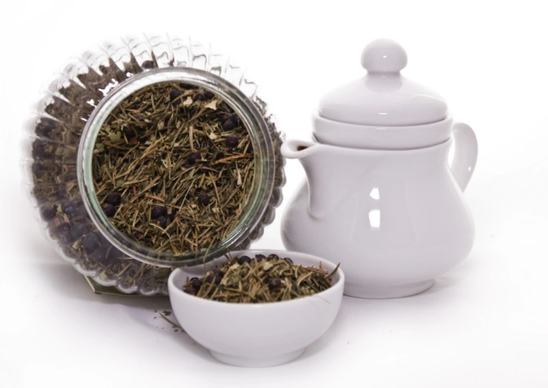 Grüntee Arya Monk ein umfallendes Glas und eine Teekanne.