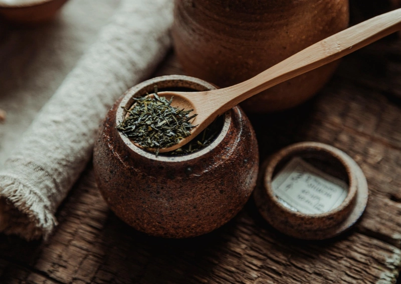 Grüntee Australian Shincha in einem Teekrug mit Holzlöffel