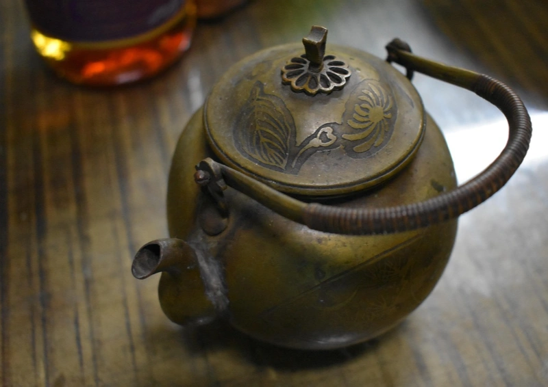 Halbfermentierter Formosa Dark Pearl Oolong in einer kupferfarbenen Kanne.