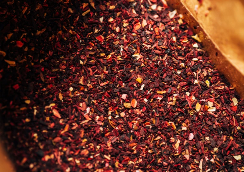 Honeybush Tee – grobe Teemischung in Papierbeutel, rötlich-goldene Farbe.