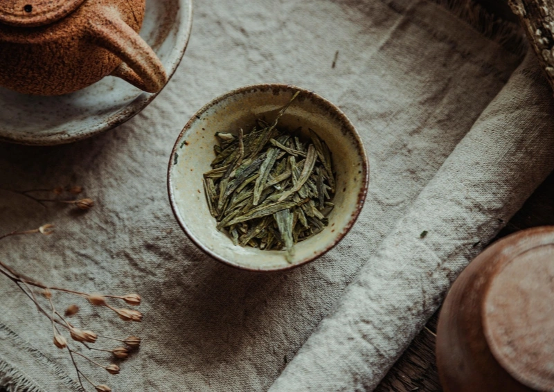 Japan Sencha Kame Silber in einer beigen Teeschale liegt der lose Tee.