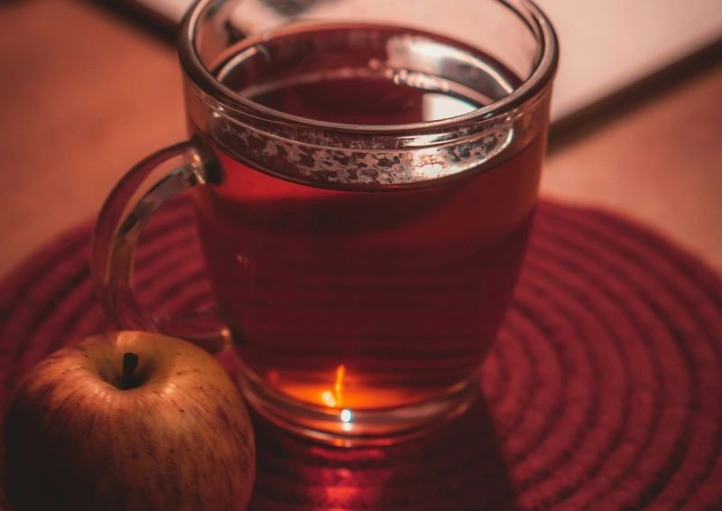 Pu Erh Kunming eingeschenkt im Glas mit Apfel.