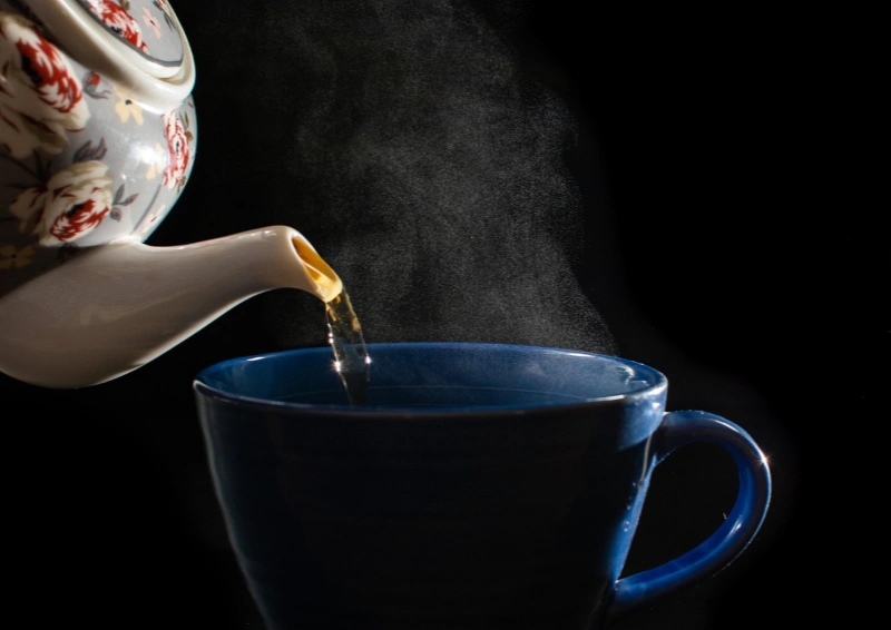 Schwarztee wird in eine blaue Tasse geschenkt.