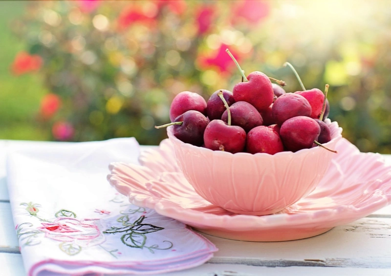 Weiße Teetasse im Freien mit frischen Kirschen für Früchtetee Cherry