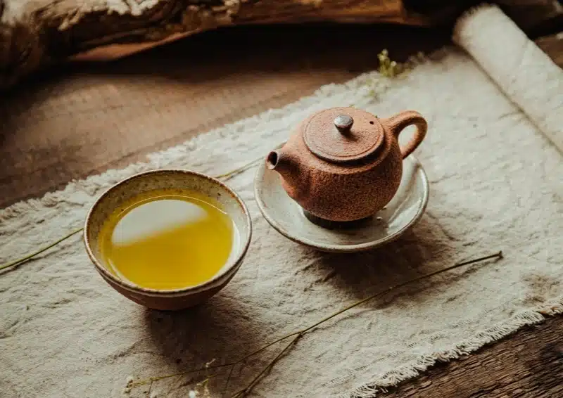 Oolongtee richtig zubereiten mit Gaiwan Teetasse mit goldenem Tee