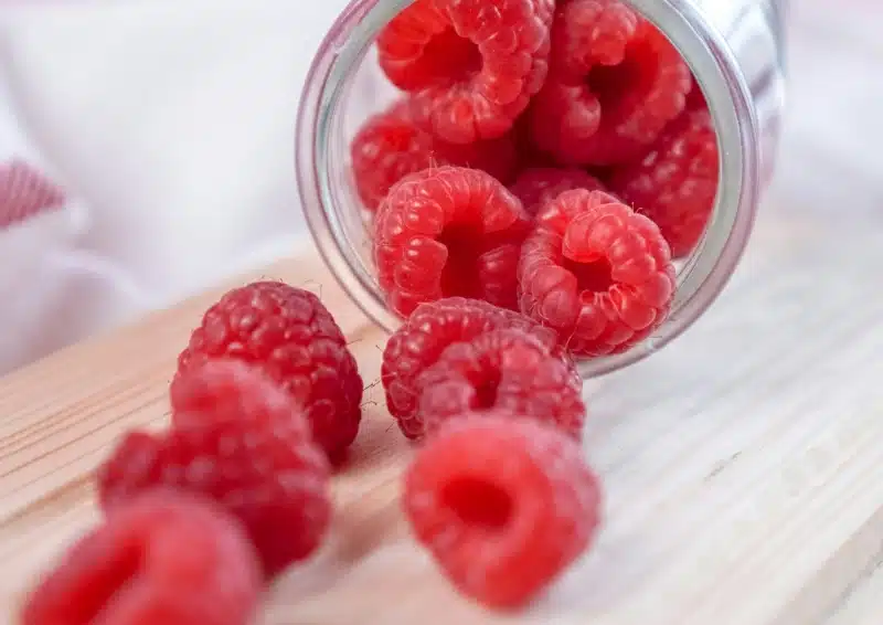 Himbeeren kullern aus einem Glas für Früchtetee Bestens drauf